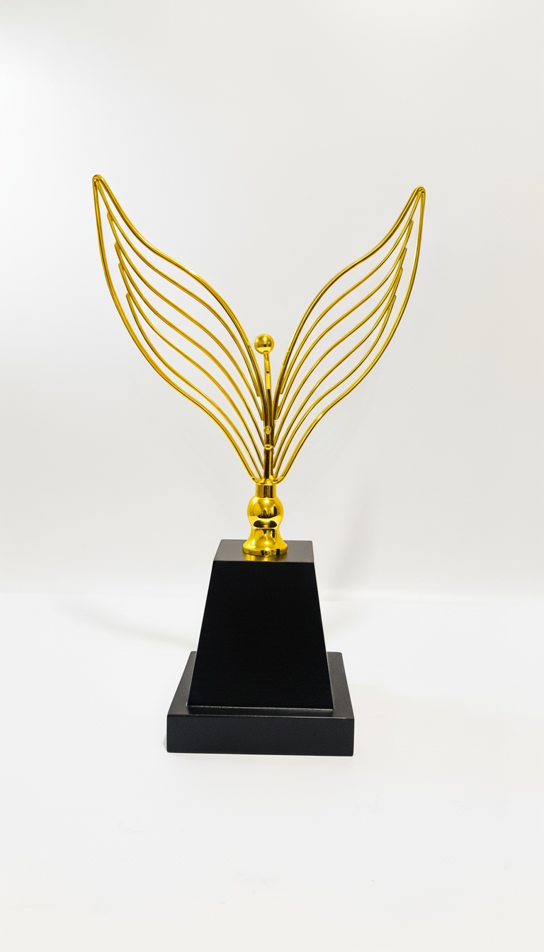 A gold-colored decorative wing sculpture mounted on a black pedestal.