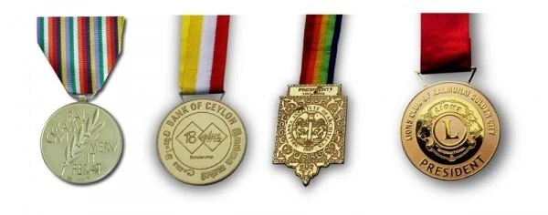 Four medals with various ribbons displayed side by side.