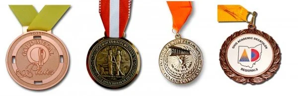 Four medals arranged in a row, each with different designs and ribbons.