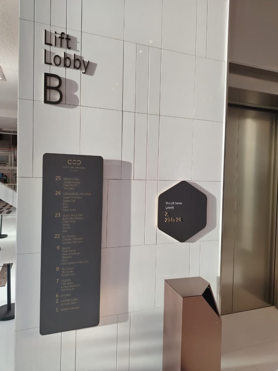Signage indicating floors and amenities at a luxury building, with elevator doors adjacent, showing levels 2 and 23 to 24.