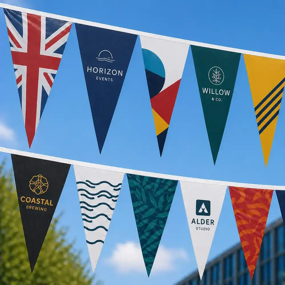 Colorful triangular fabric banners hanging outdoors against a blue sky, featuring logos and names of various brands such as Horizon Events, Willow & Co., Coastal Brewing, Alder Studio, and others.