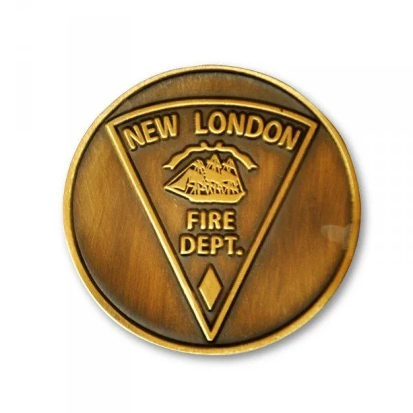 Brass fire department badge for New London Fire Department with a triangle and mountain graphic.