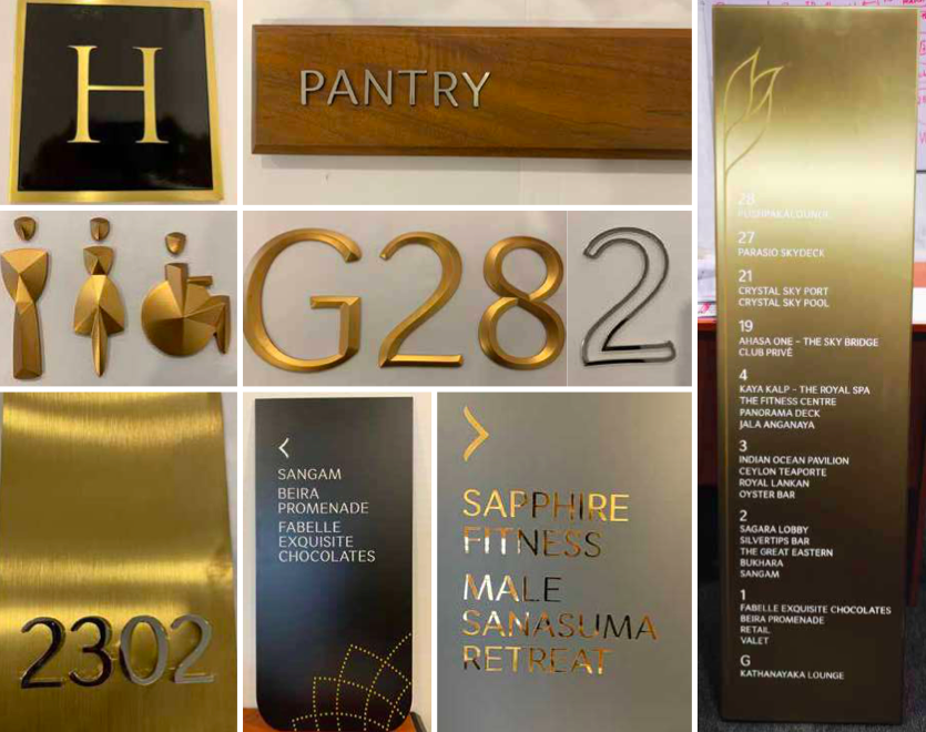 Collage of signs and plaques including a black and gold letter H, a wooden sign labeled PANTRY, gold and silver decorative numbers G28.2, a gold plaque with room number 2302, a dark sign listing places like Sangam, Beira Promenade, and Fabelle Chocol