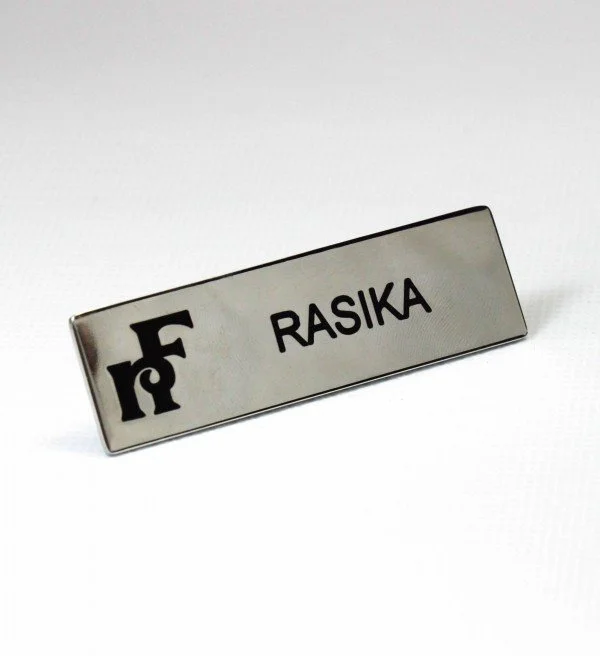 A name tag with the name 'RASIKA' and a logo with the letters 'F' and 'r'.