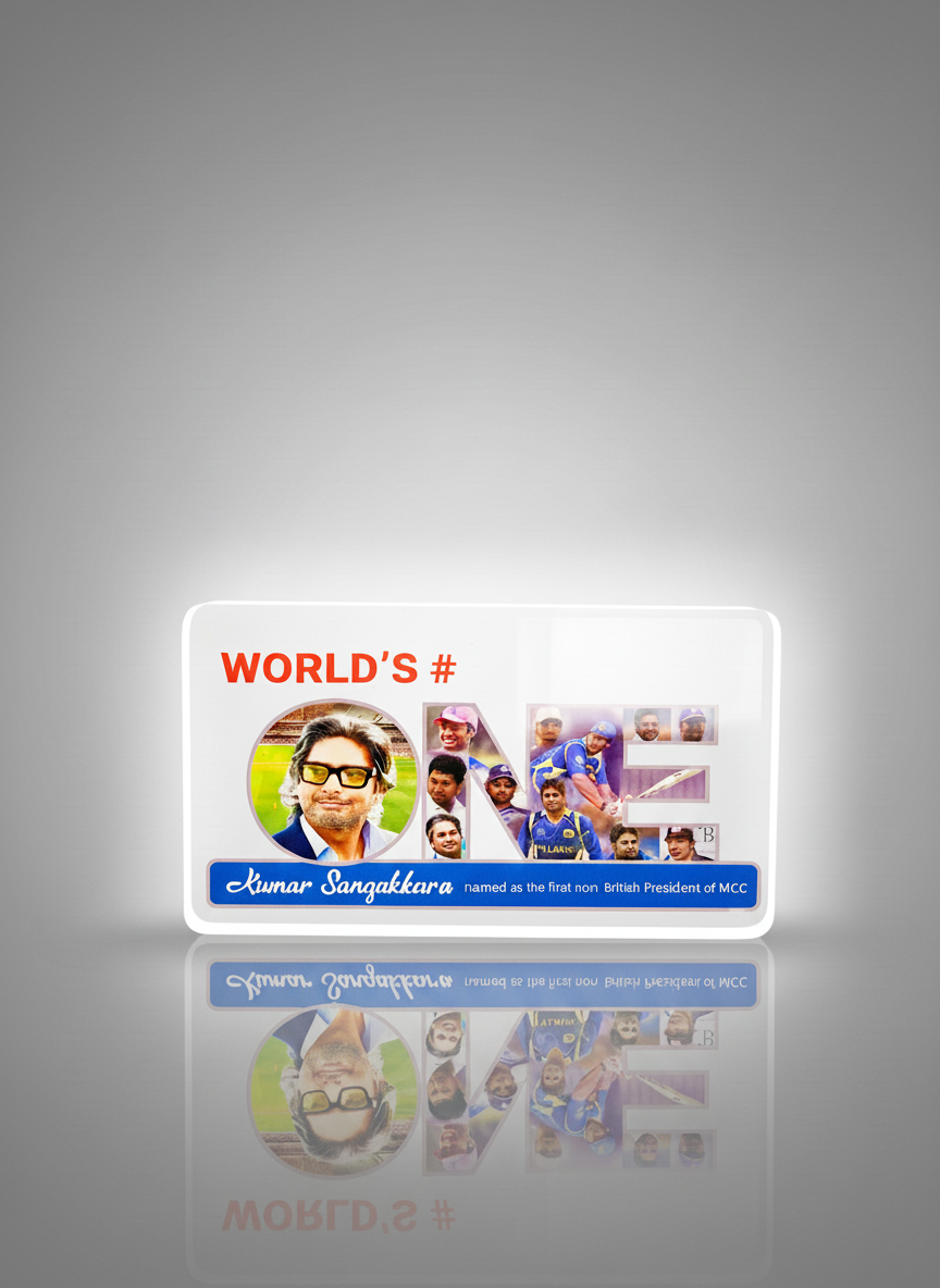 A white card with the text 'WORLD'S #' in red at the top, featuring a large picture of a man with glasses and dark hair on the left and a collage of Indian cricket players on the right. There is a blue strip at the bottom with the name 'Kumar Sangakk