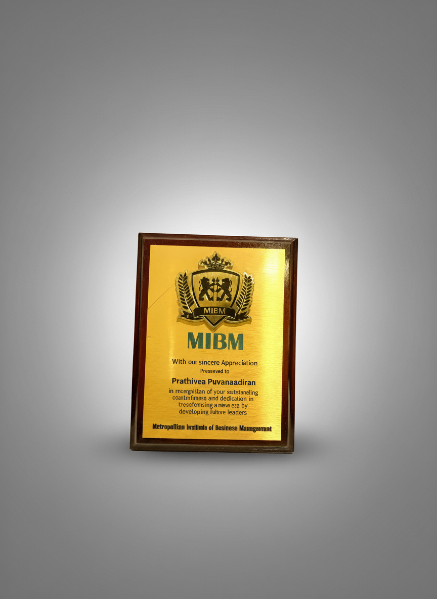 Gold-colored award plaque with black and green text, decorated with a crest at the top, presented to Prathivea Puvanaadiran for appreciation by the Metropolitann Institute of Business Management.