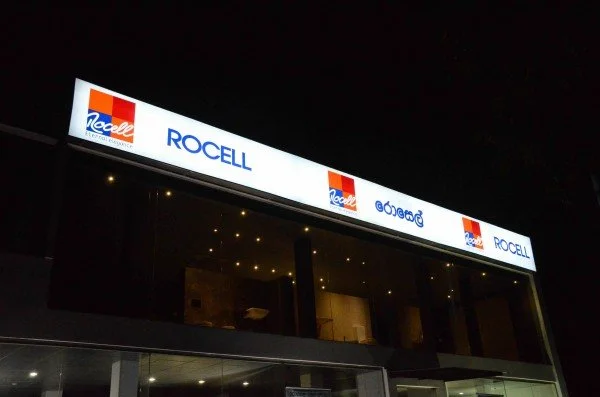 Bright illuminated sign showing the logos for Kellogg and ROCELL at night.