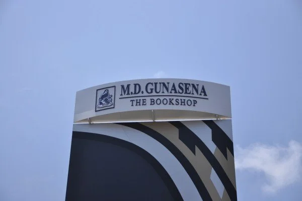 Sign for M.D. Gunasena The Bookshop against a cloudy sky.