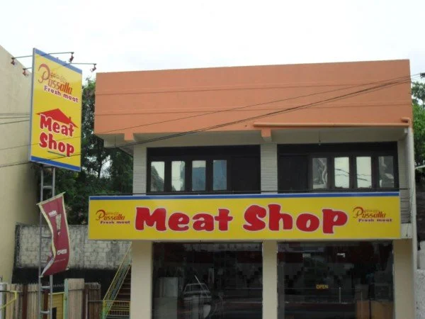 Exterior of a meat shop with yellow and red signage.