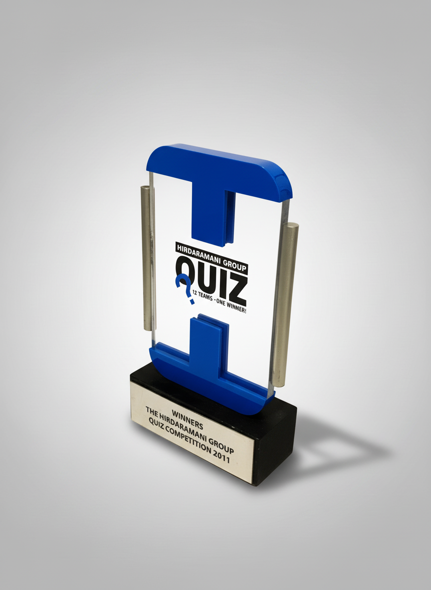 An award trophy for the Hirdaramani Group Quiz, featuring a large blue letter 'L' on a black base, with an inscription for the winners of the 201-1 quiz competition.