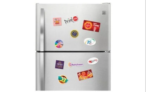 Silver refrigerator with various colorful magnets and stickers on the door