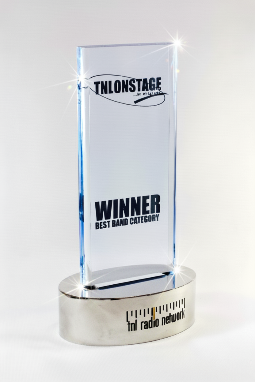 A clear glass award trophy with the text 'TNL ONSTAGE' and 'WINNER BEST BAND CATEGORY' engraved; the base has the logo 'tni radio network'.