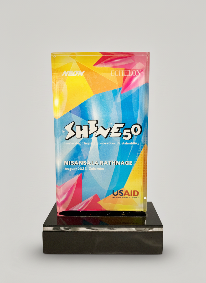 Colorful award plaque with geometric patterns, text, and logos, displayed on a black base against a plain background.