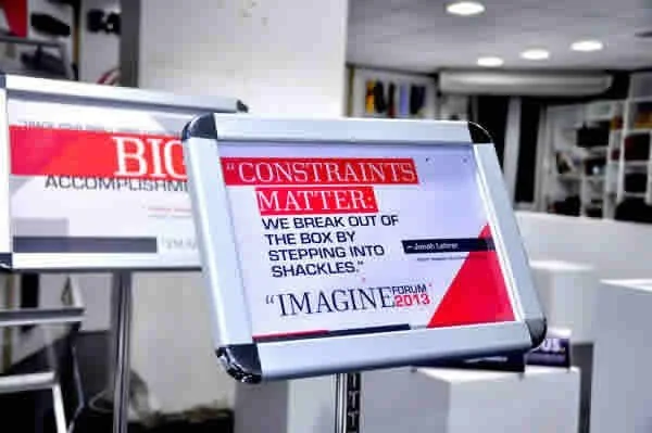 Digital sign displaying a quote about constraints and breaking out of the box at a conference or forum.