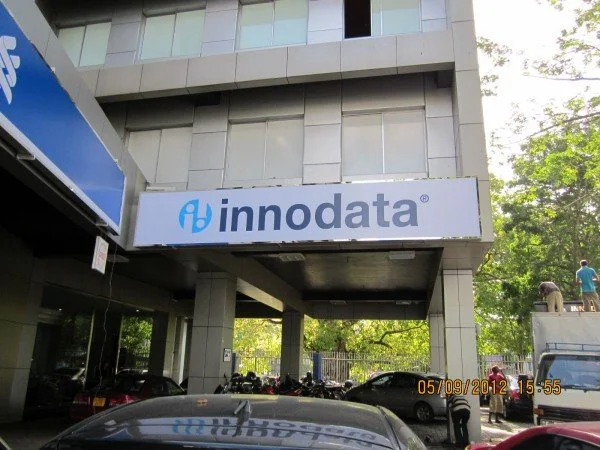 Innodata company building with parking lot and some people outside