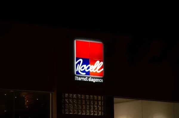 Illuminated Totall logo with red, white, and blue branding and the slogan 'Eternal elegance' against a dark background.