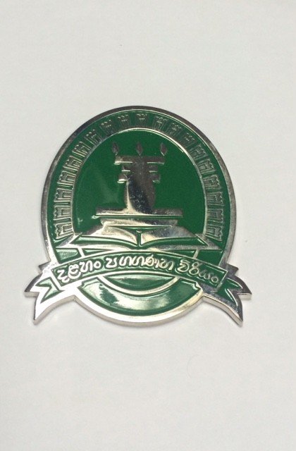 A green and silver medal with a candle and Thai text on it.