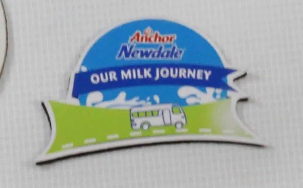 A label from Anchor Newdale with the text "Our Milk Journey" and an illustration of a green double-decker bus on a road.