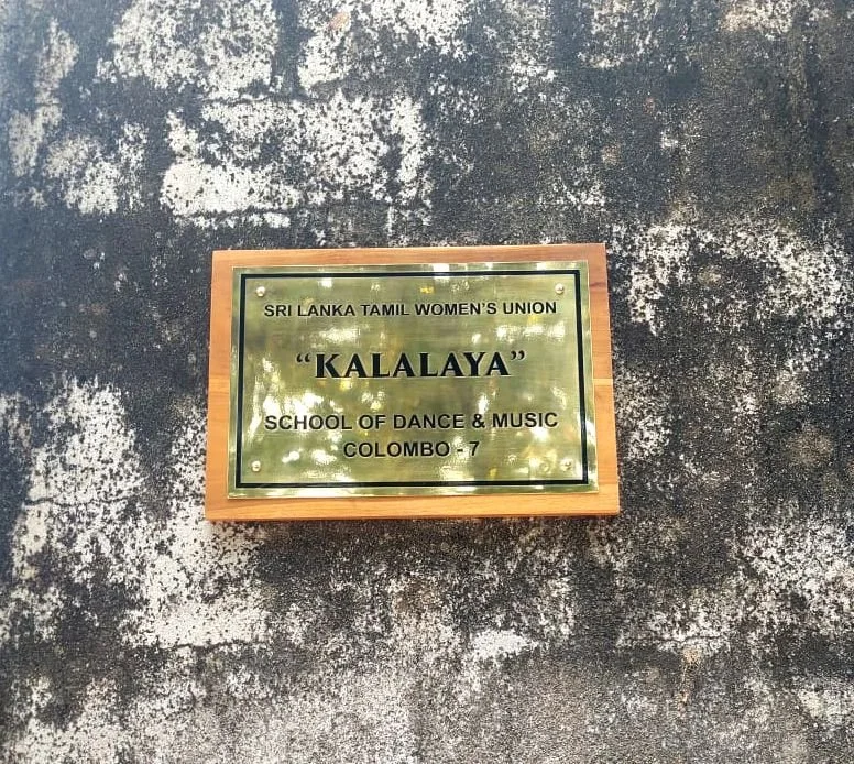 A plaque mounted on a textured wall, indicating the name of a school of dance and music called Kalalaya, associated with the Sri Lanka Tamil Women's Union in Colombo, Sri Lanka.