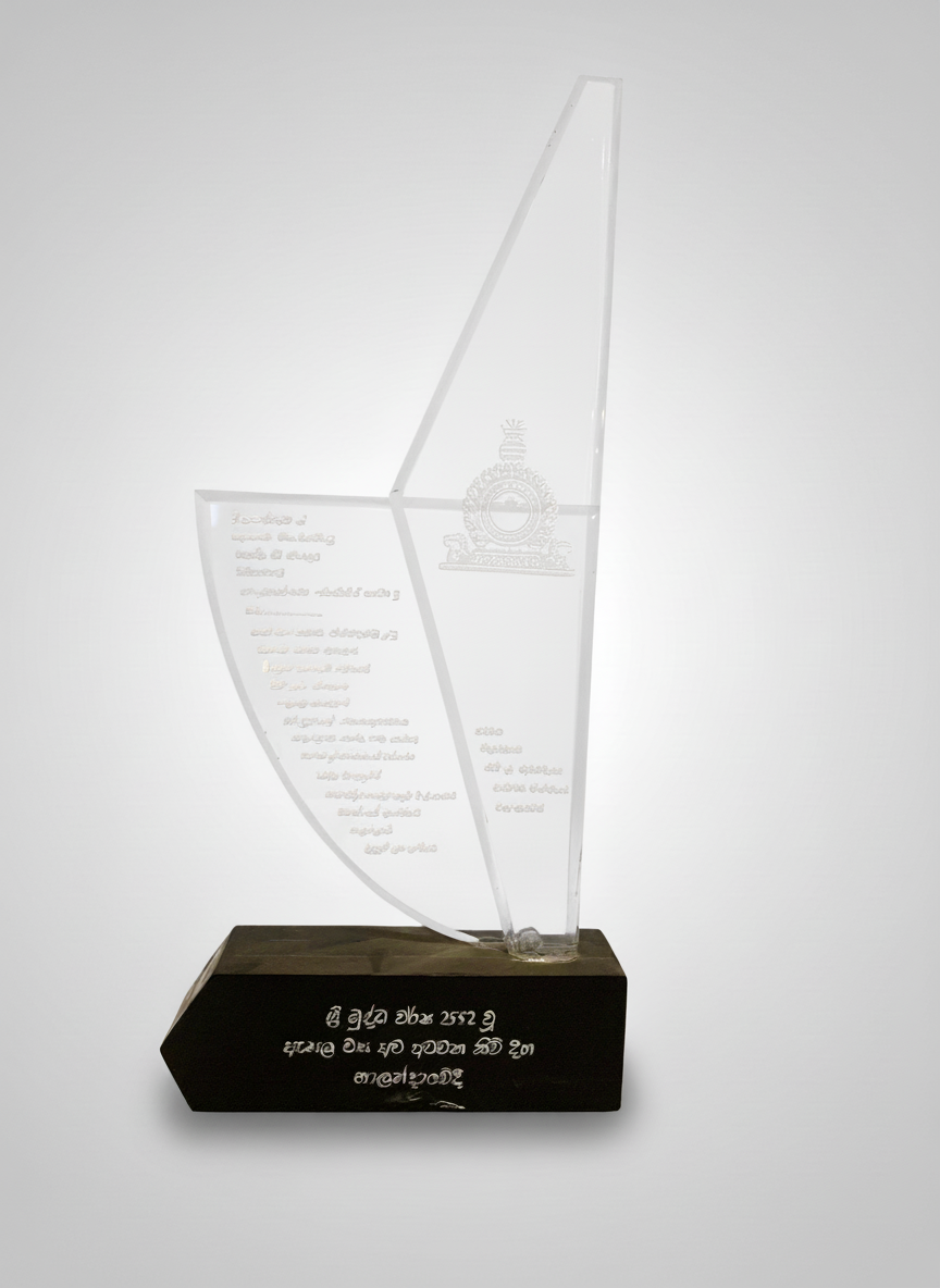 A transparent award trophy with engraved text and emblem, mounted on a black base