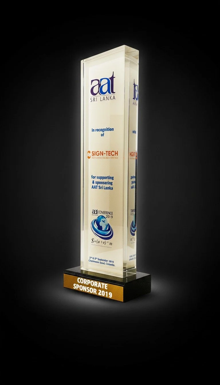 A glass award-like block with text recognizing support for AAT Sri Lanka at the AEIC Conference 2019, placed on a black base that says "Corporate Sponsor 2019."