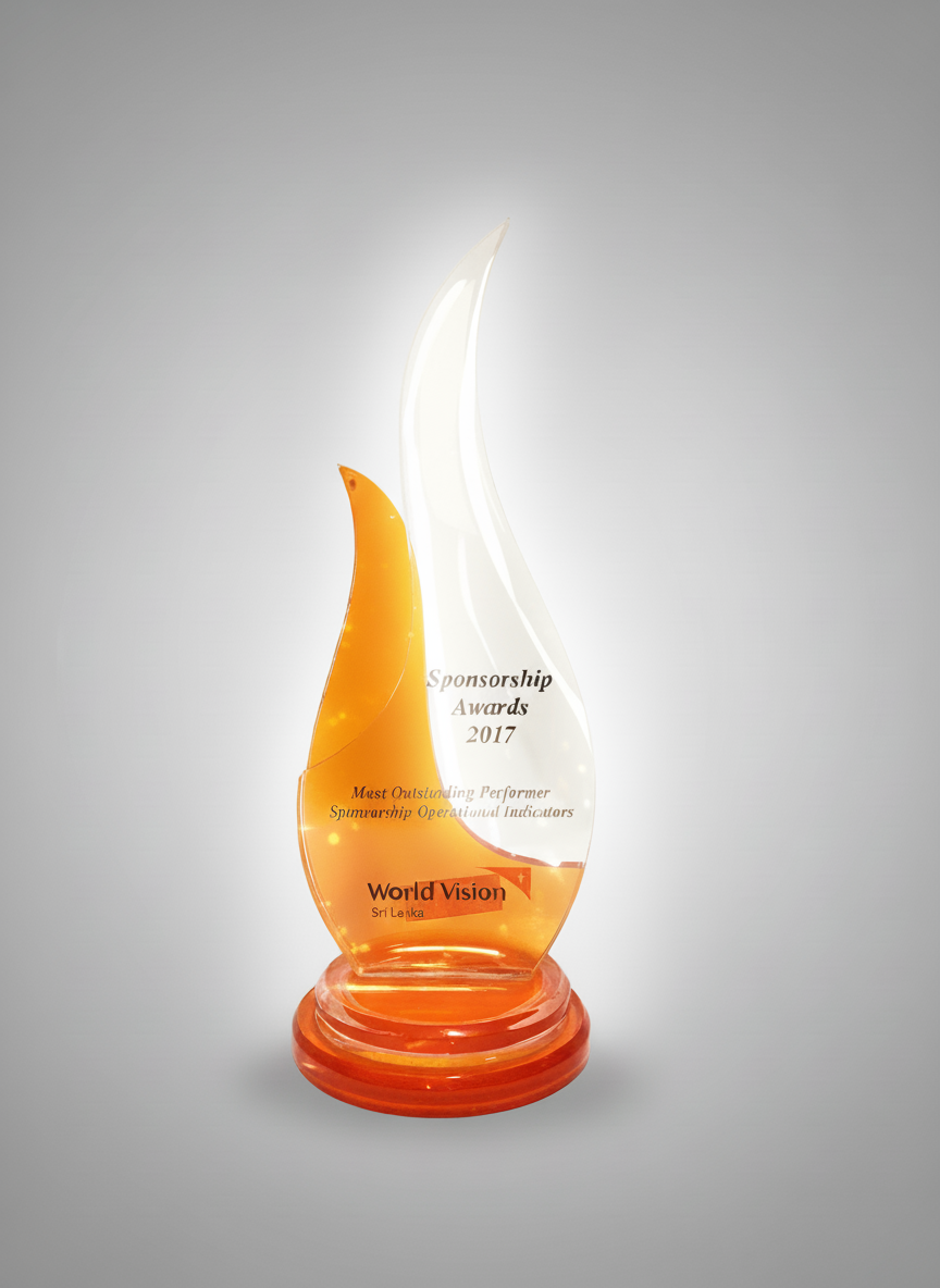 Clear glass award with orange accents, inscribed with 'Sponsorship Awards 2017,' recognizing Sri Lanka for outstanding performance in sponsored operational indicators, titled 'World Vision'.