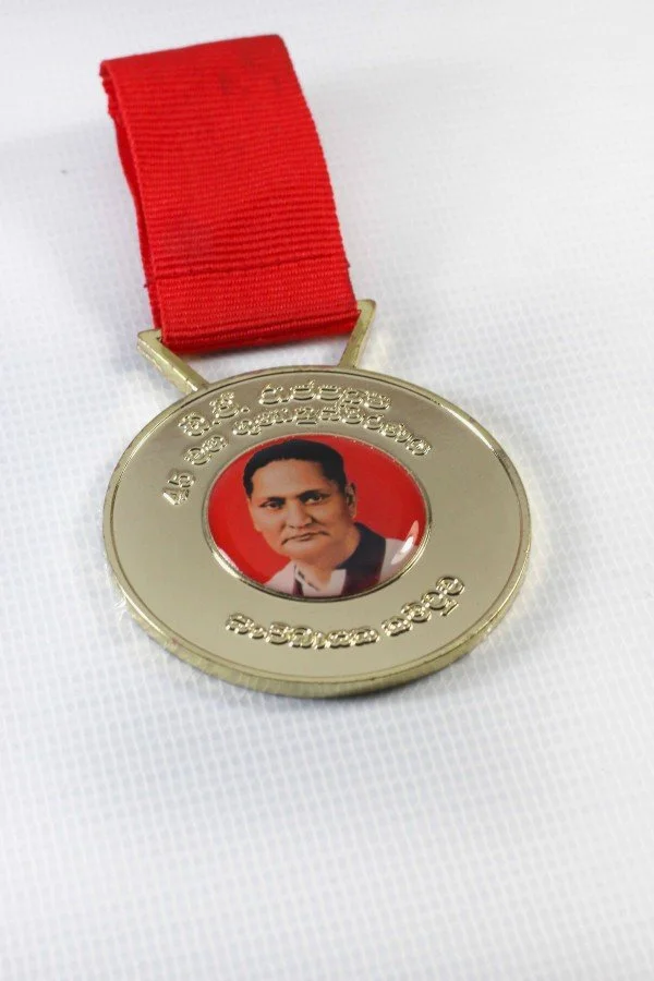 Medal with a red ribbon and a central photo of a man against a red background.