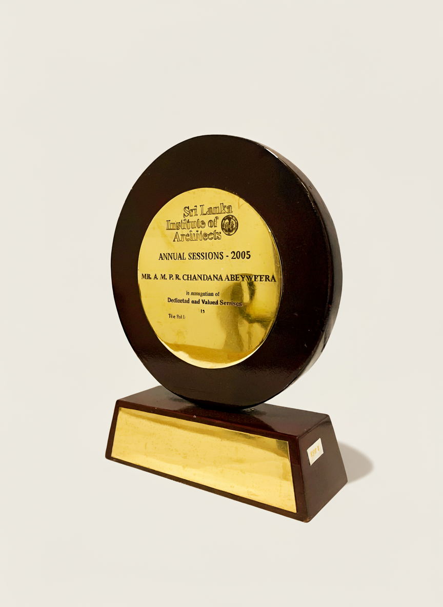 Trophy or award with gold-colored plaque inscribed with 'Sri Lanka Institute of Architects, Annual Sessions 2005, Mr. A. M. P. R. Chandana Abeyweera' and a wooden base.
