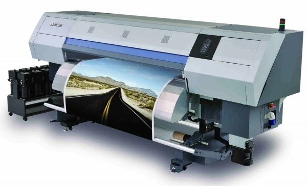Large industrial inkjet printer printing a landscape photo of a road through mountains.