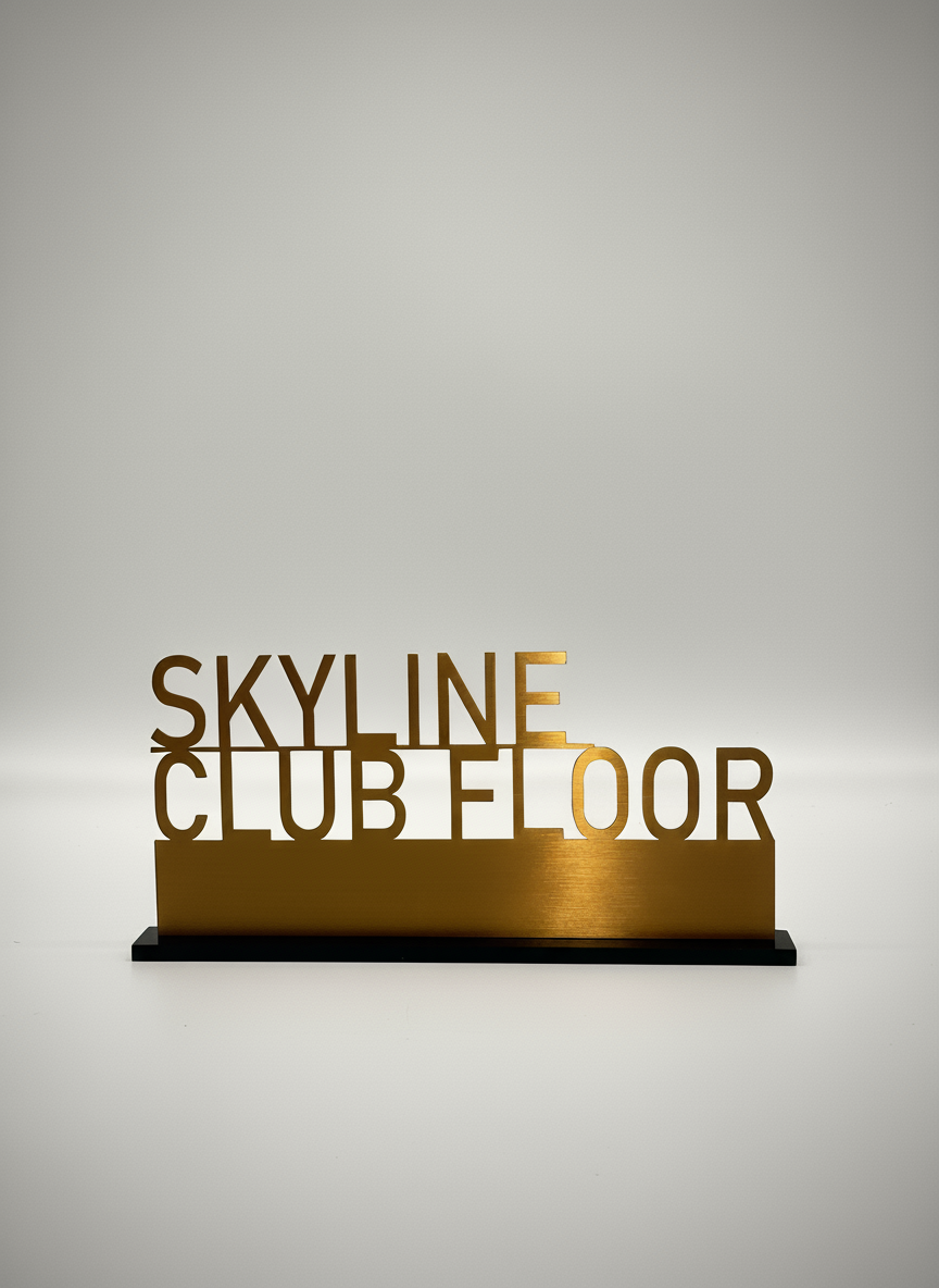 Gold-colored sign with the words "Skyline Club" and "Floor" on a plain white background.