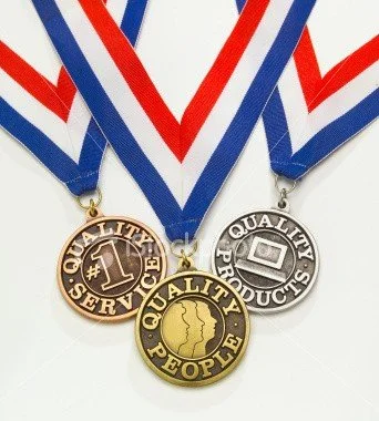 Three medals hanging from red, white, and blue ribbons.