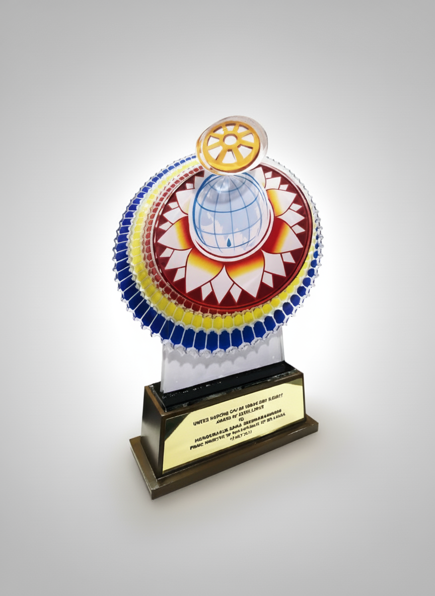 Colorful award trophy featuring a globe, a wheel, and a lotus flower design on the top, mounted on a black base with a plaque.