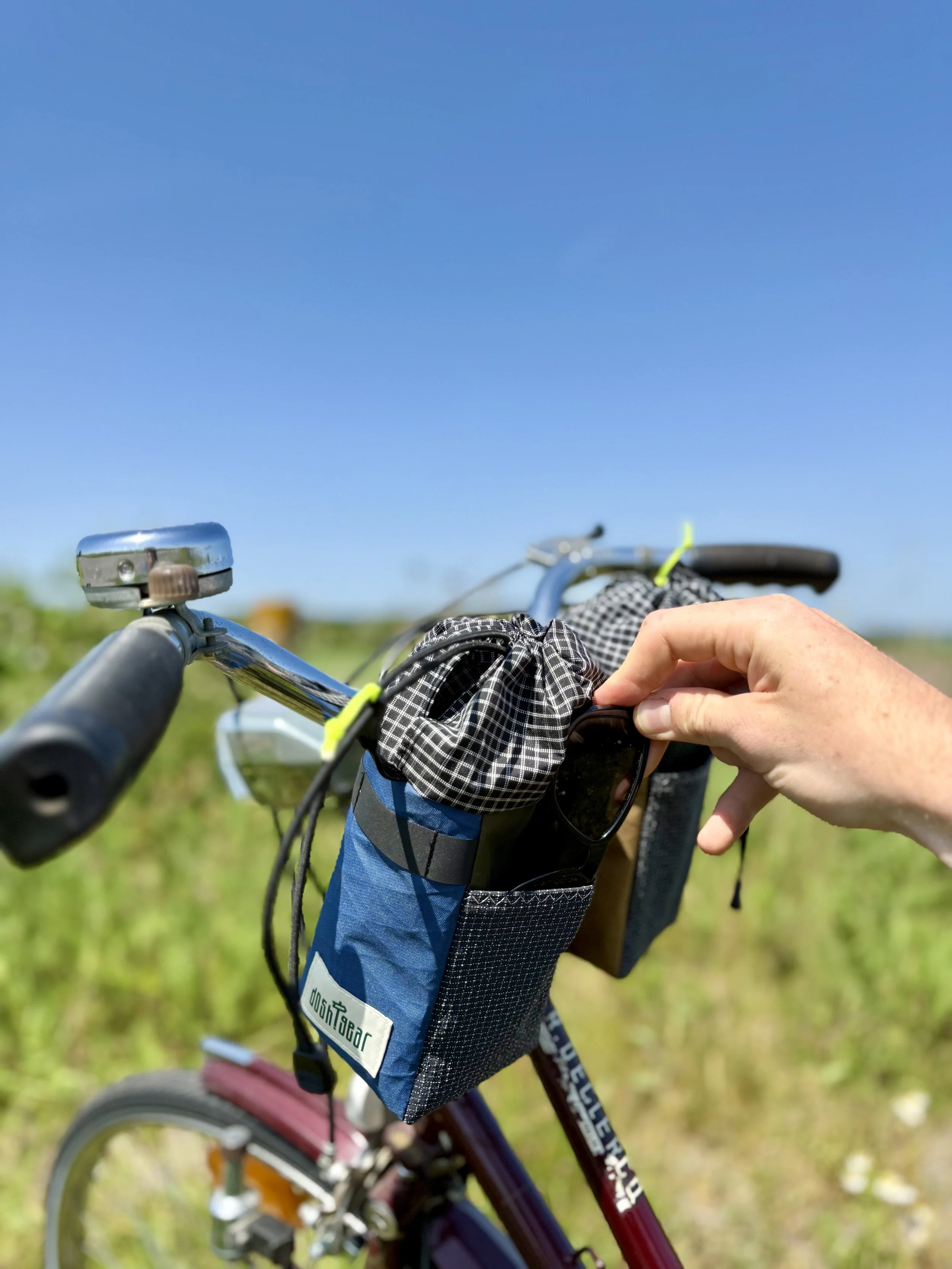 custom made bucket bag snacl pouch on a handlebar of a bike. opening with one hand