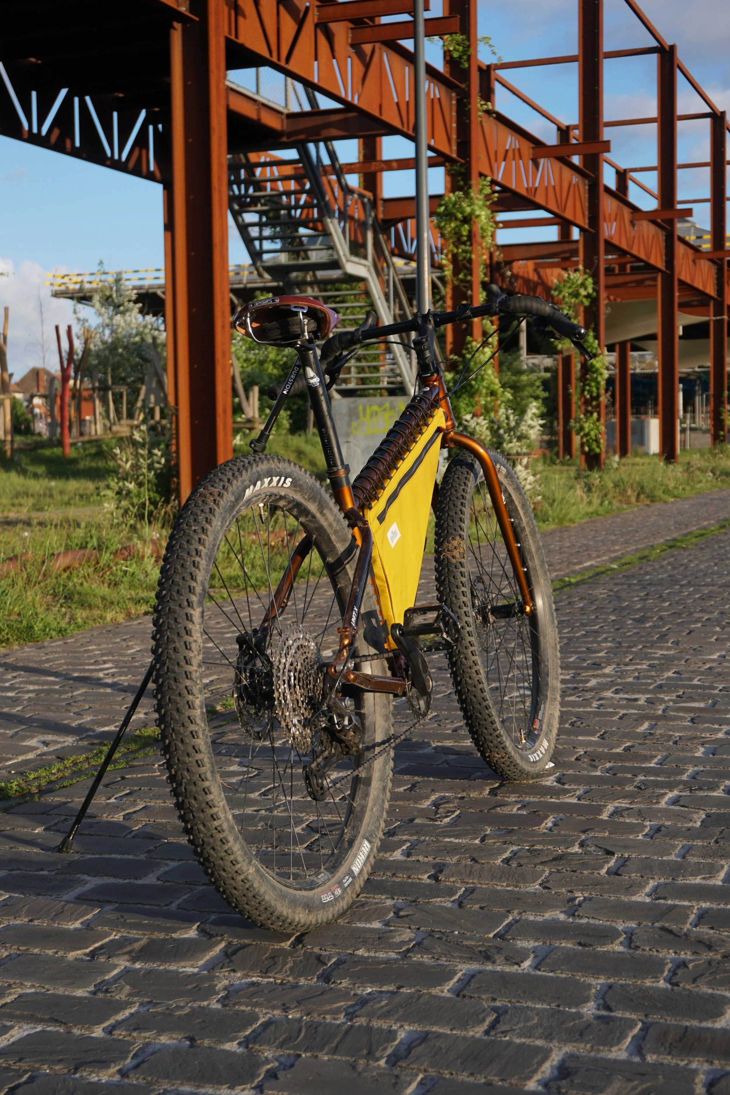 Kona Unit X steel mtb with Surly corner bars and a yellow custom made frame bag