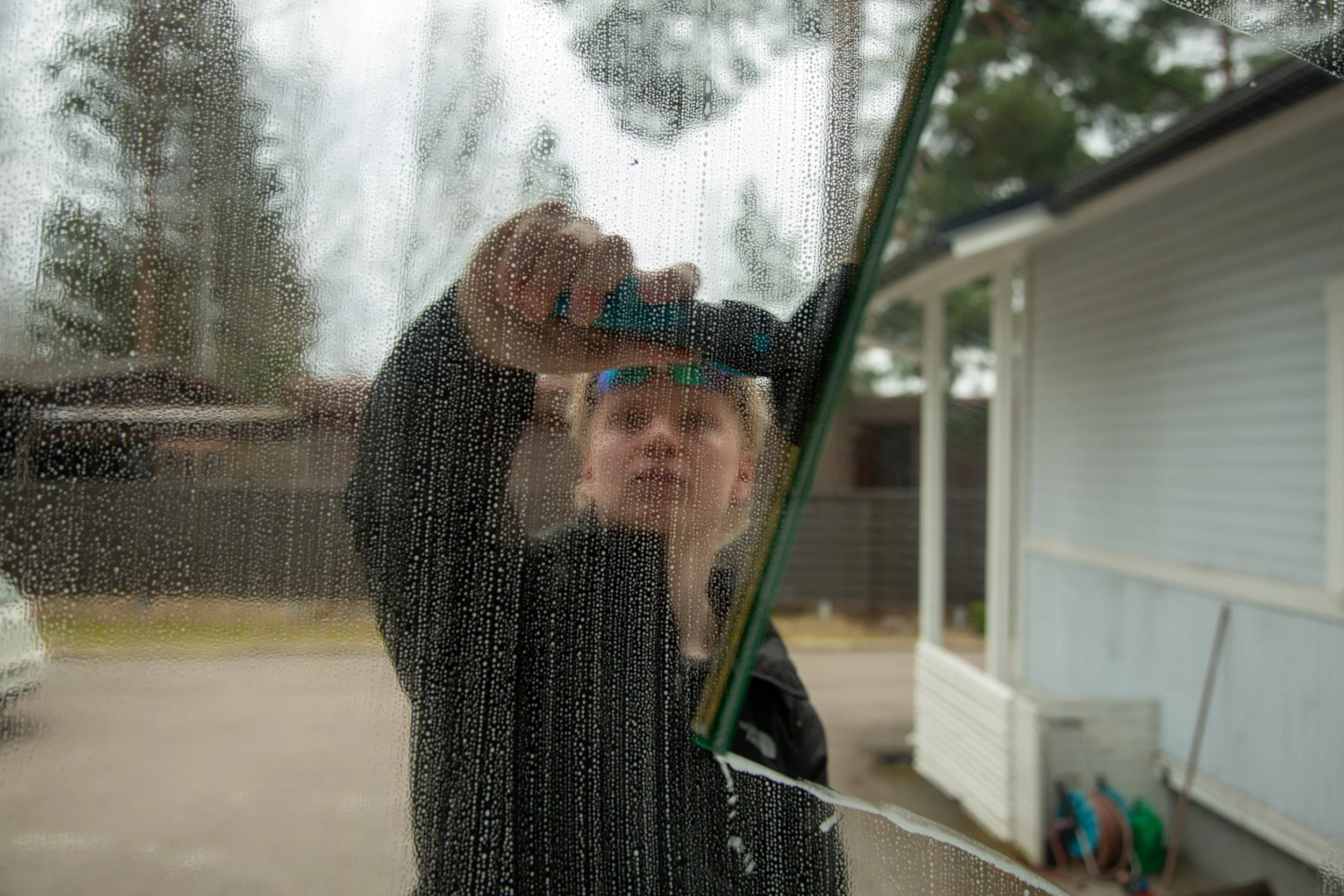 Person cleaning a glass window with a squeegee