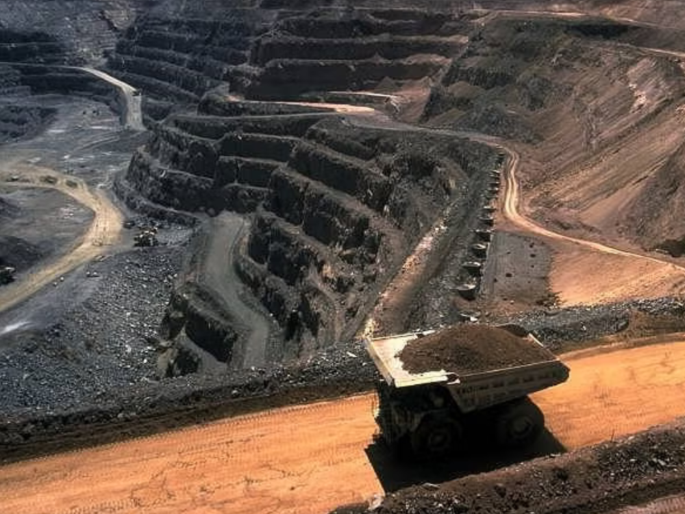 strip mine with construction vehicle driving on road