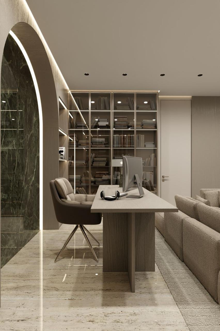 Modern office interior with a computer desk, swivel chair, shelves with books, and decorative lighting. The room features minimalistic design with neutral colors and a marble floor.