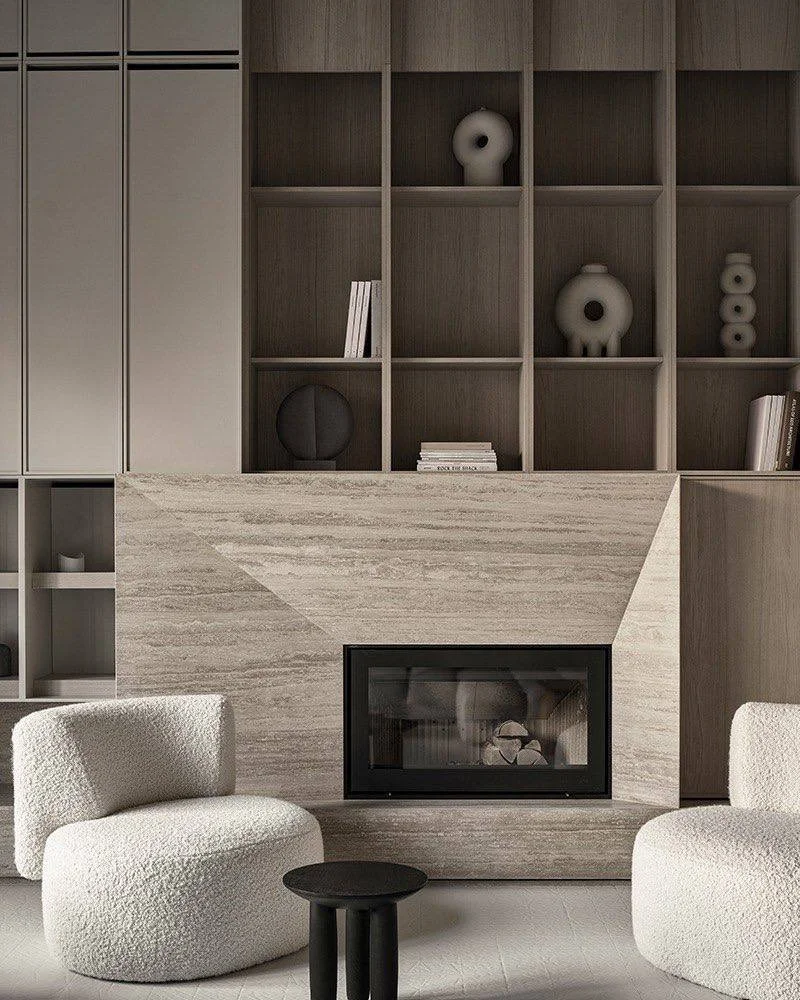 Modern living room with minimalist design featuring a stone fireplace, built-in wooden shelves with decorative objects, white boucle chairs, and a small black side table.