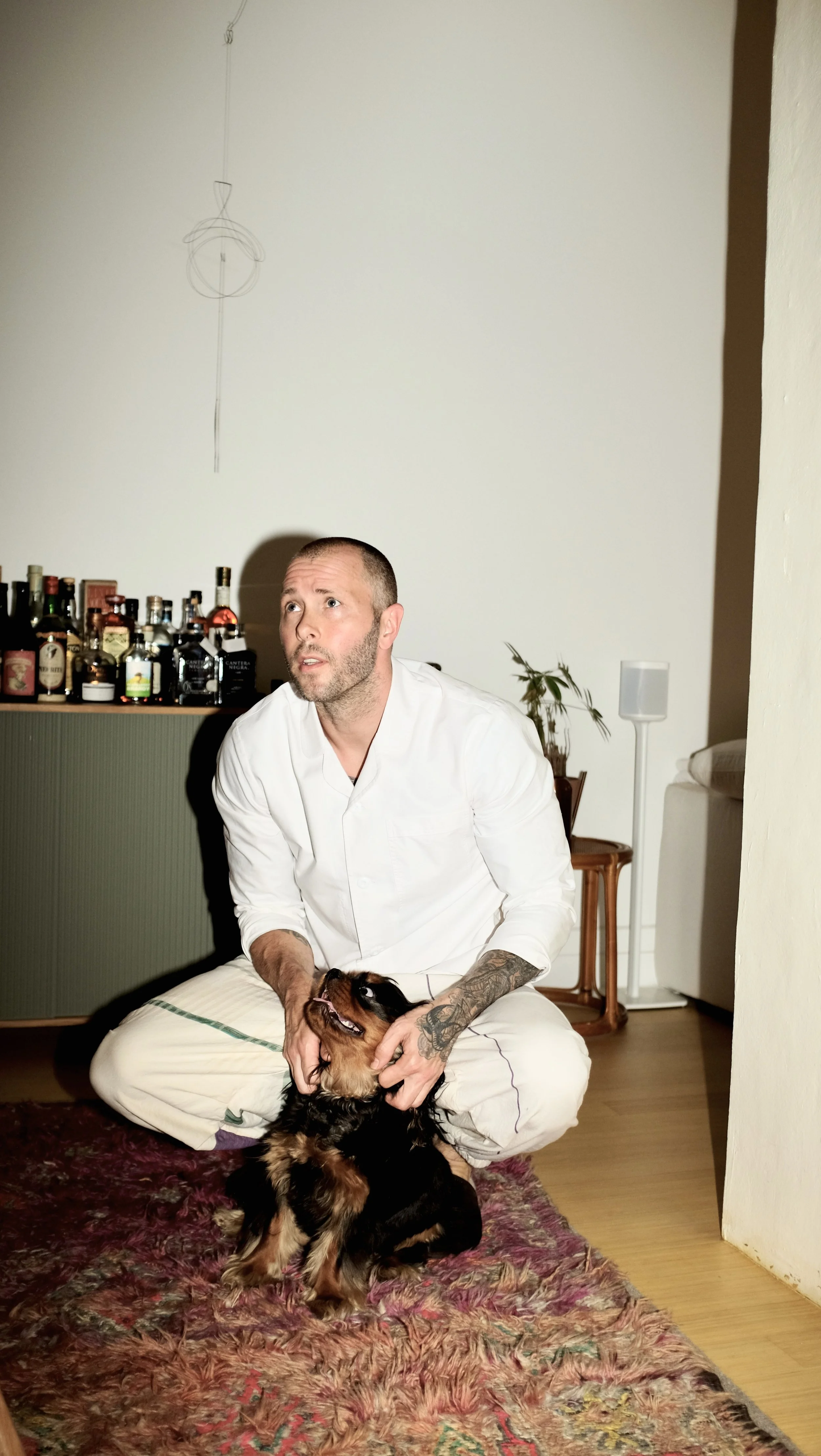 Mike Bagale petting dog while wearing the white chef coat designed by Finery.