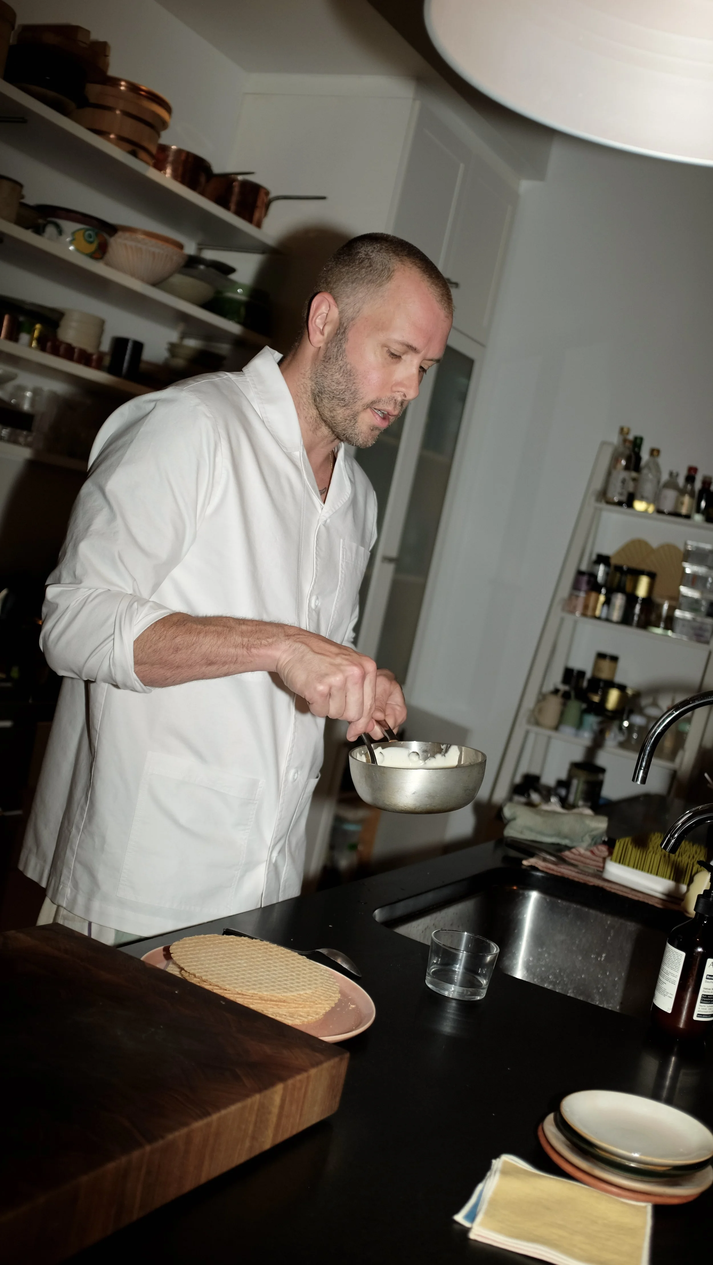 Mike Bagale cooking and wearing the white chef coat designed by Finery.