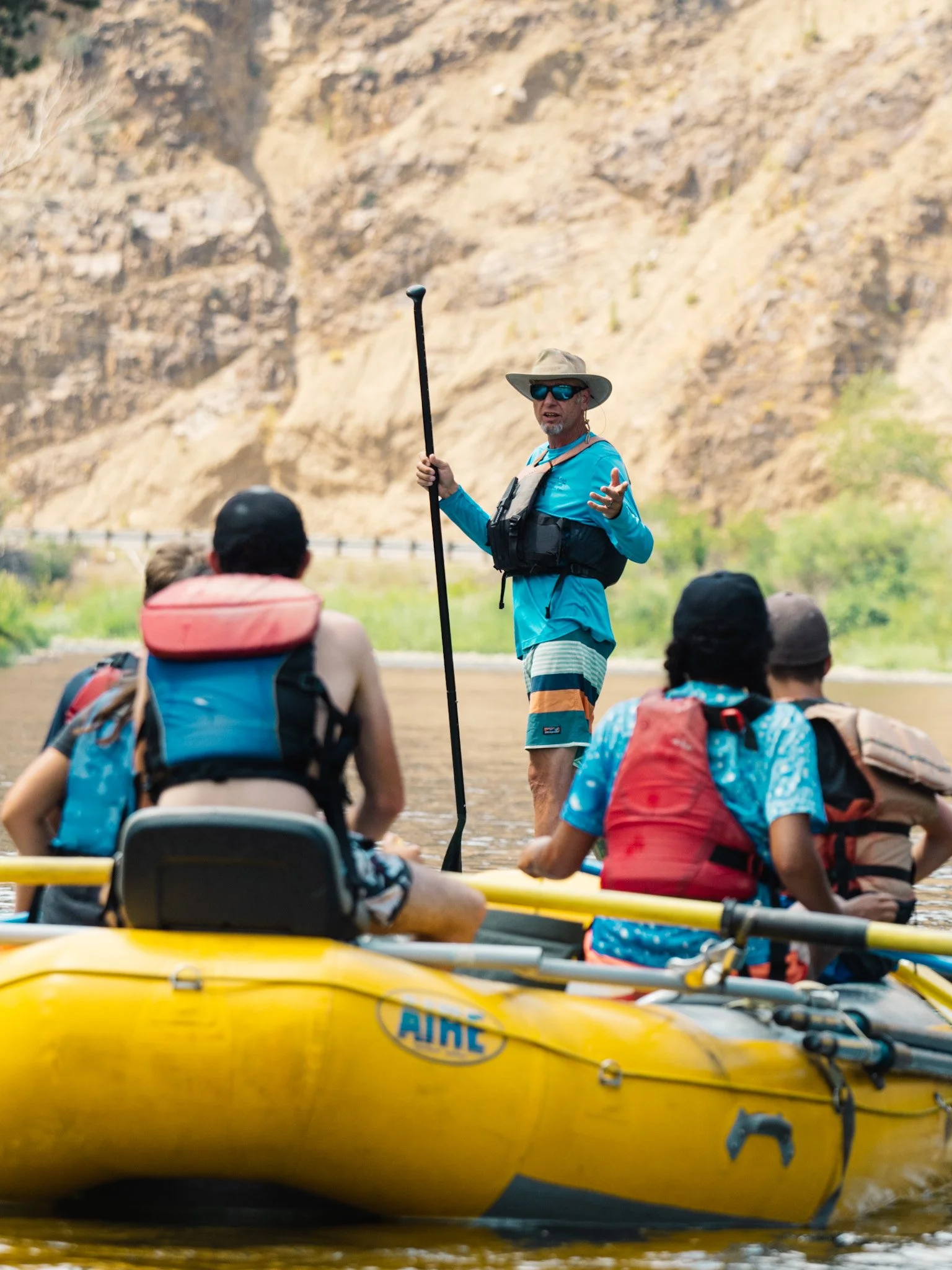 MRA founder and instructor leads a group who are seated in a raft.