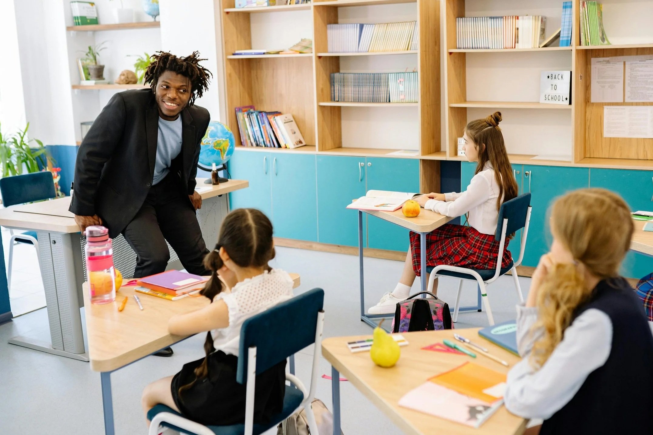 A teacher engaging students during an interactive lesson in a modern elementary classroom.