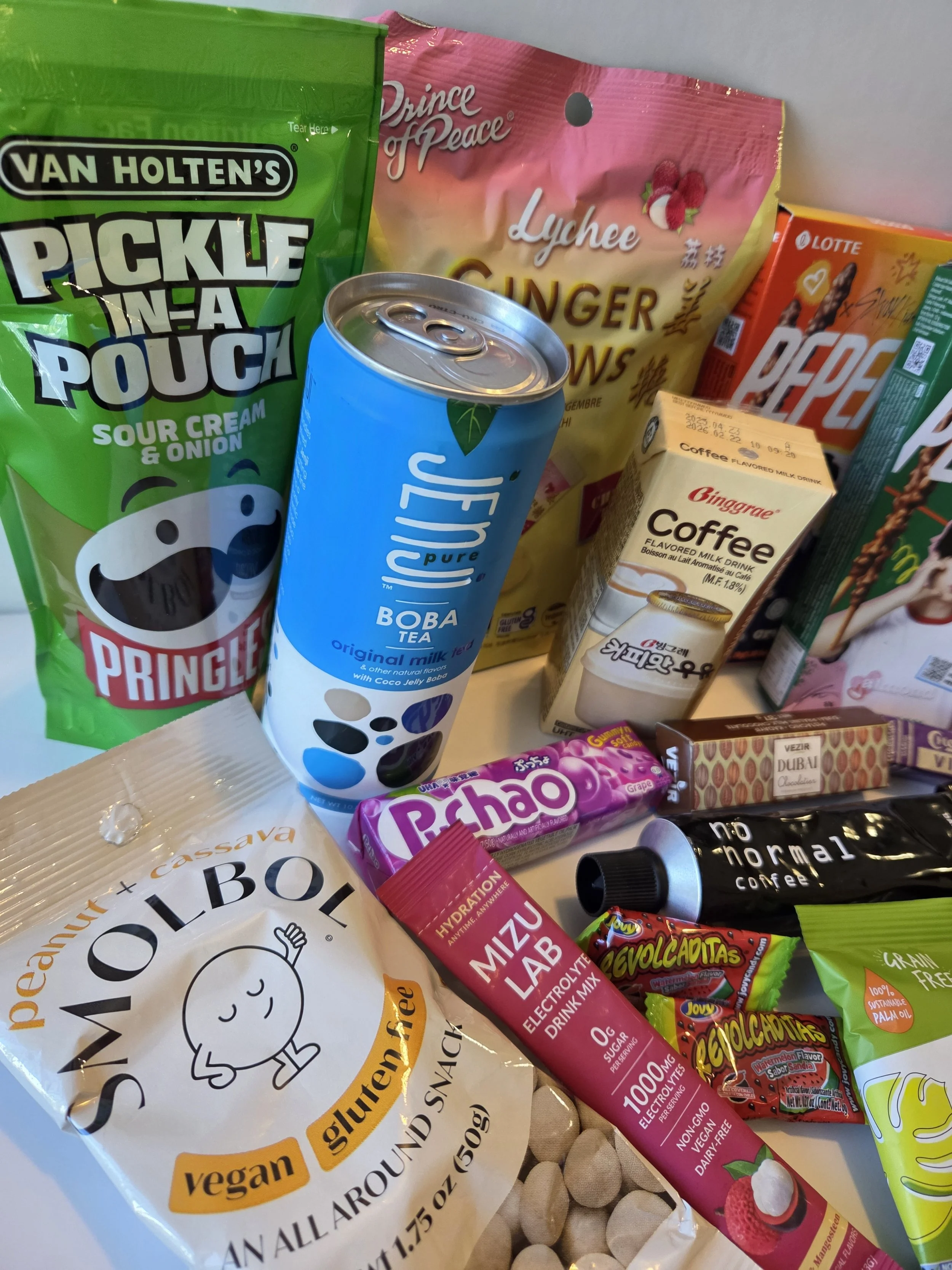 Angled views showing a variety of international snacks and beverages included in a Try The World food subscription box.