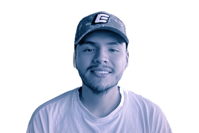 A young man wearing a baseball cap and a striped shirt, smiling at the camera.