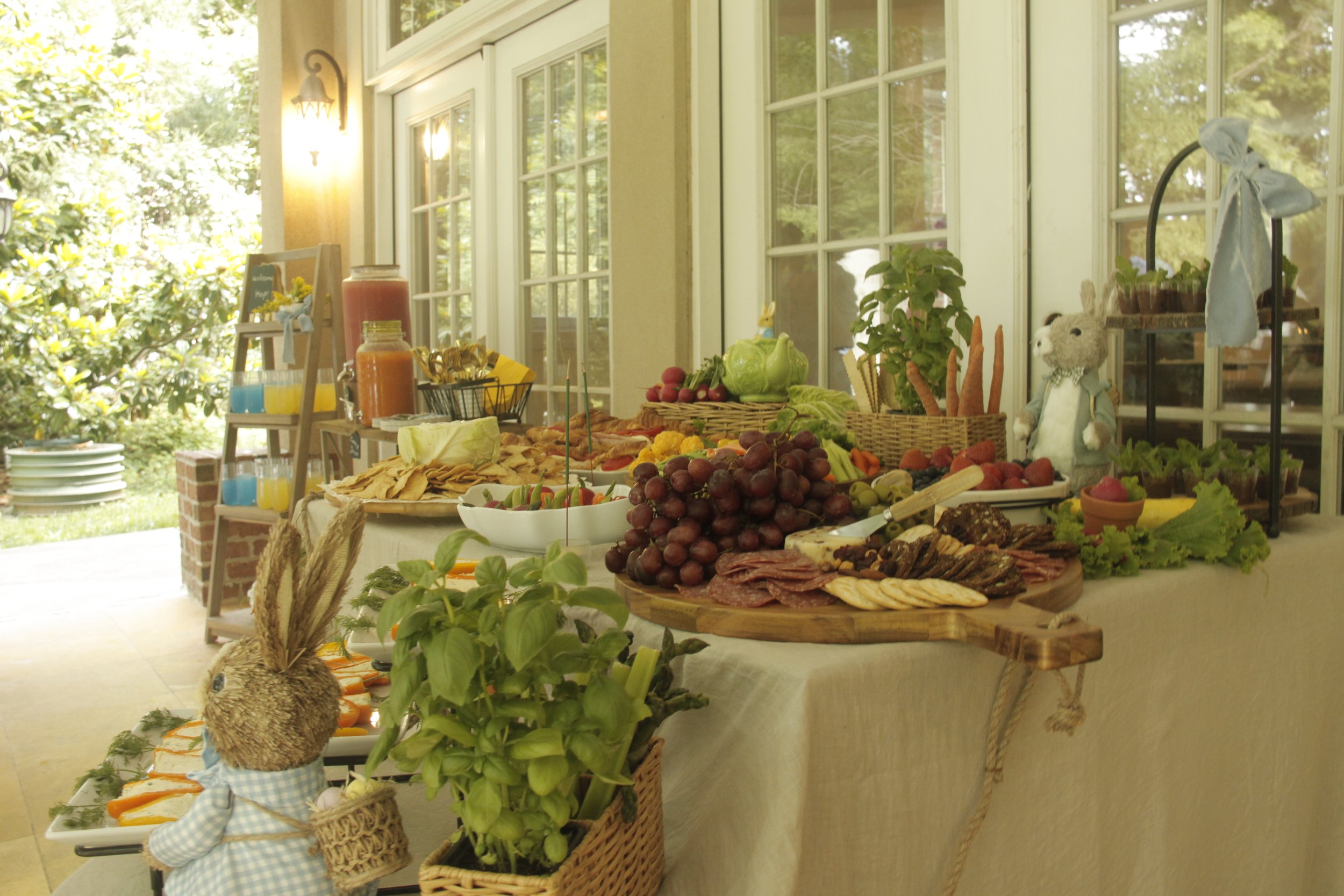 Our beautifully curated Peter Rabbit-inspired grazing table is a feast for both the eyes and taste buds. Overflowing with fresh fruits, artisanal cheeses, charcuterie, crisp vegetables, and gourmet crackers, this charming spread is styled with whimsi