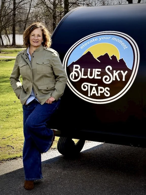 Women standing by Blue Sky Taps mobile bar and tap trailer and bar service in park setting under a sunny sky located at a wedding in Columbus, Ohio.