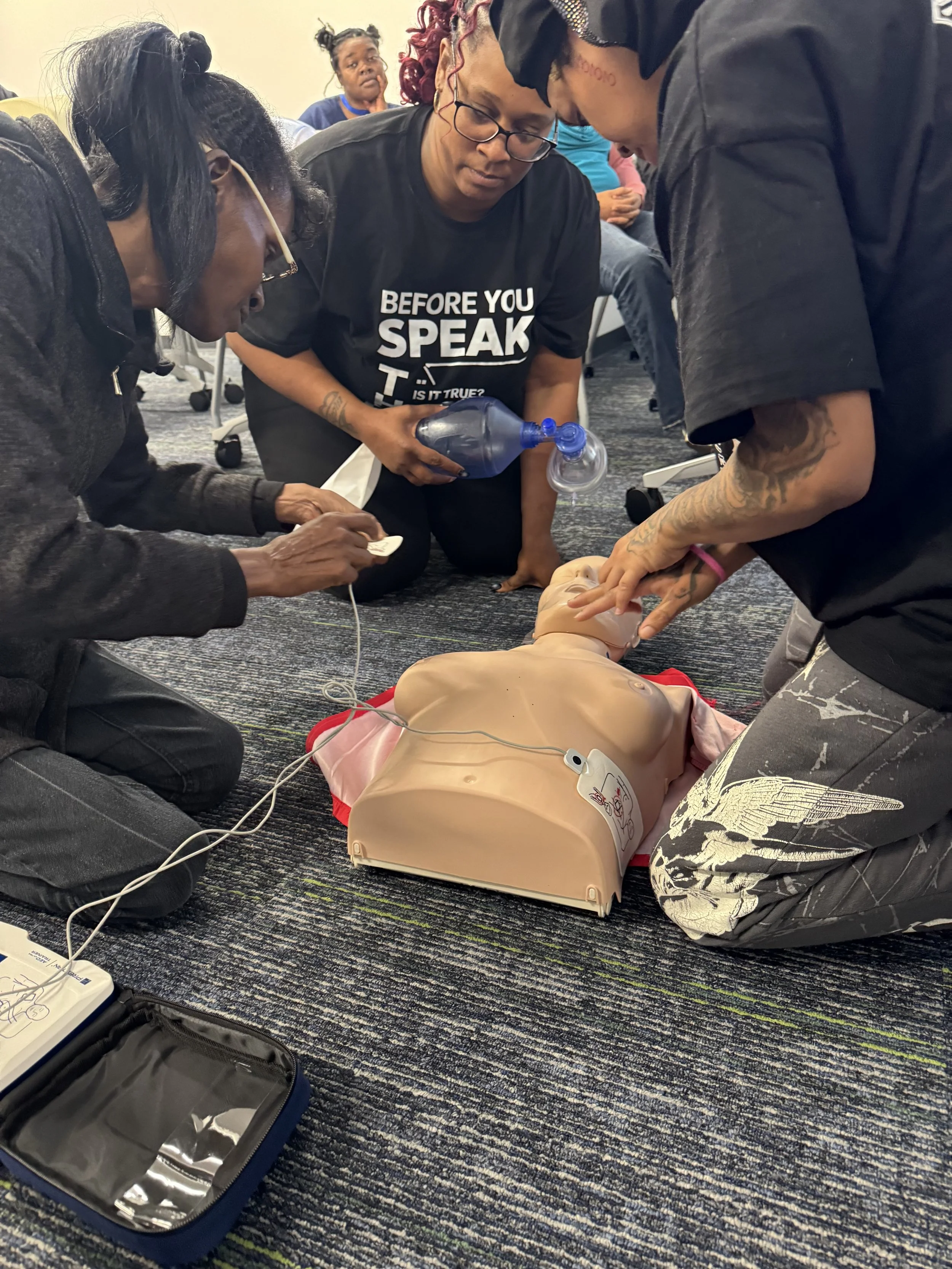 Group of people practicing CPR on a training mannequin during a CPR training class, with a focus on chest compressions and rescue breathing.