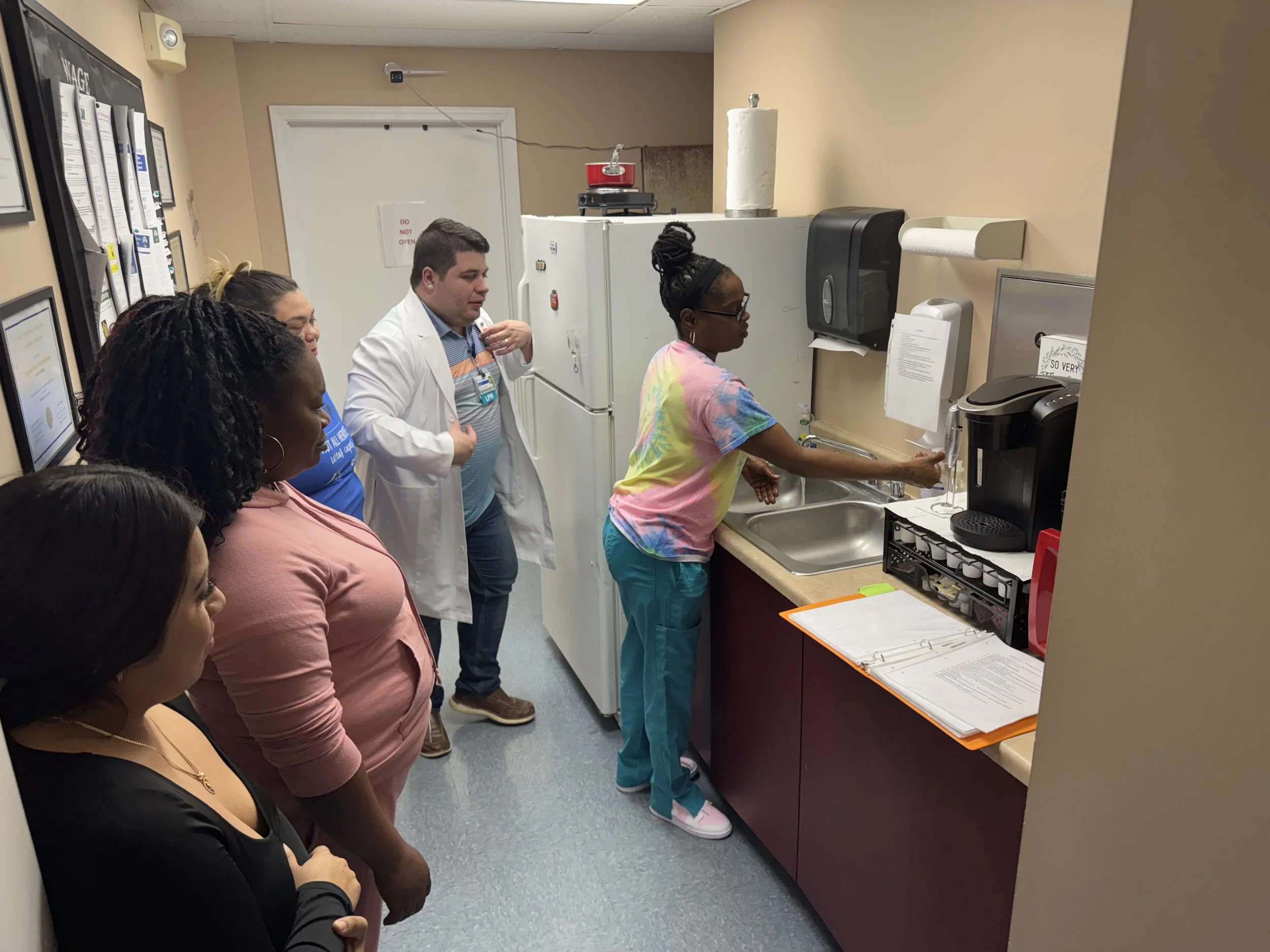 A class and instructor observing a student Performing hand hygiene skill.