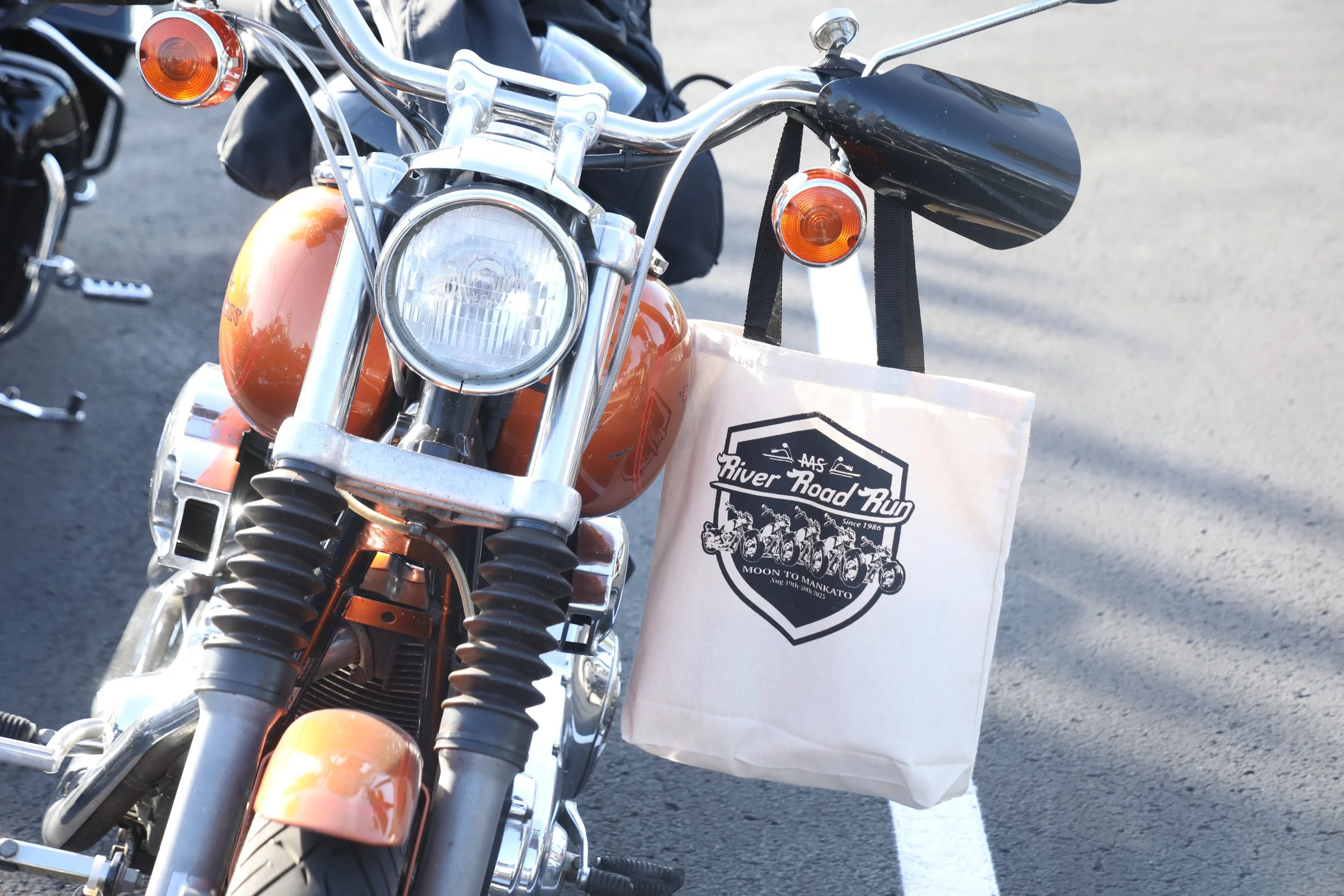 Motorcycle with MS River Road Run swag bag hanging from the handlebar