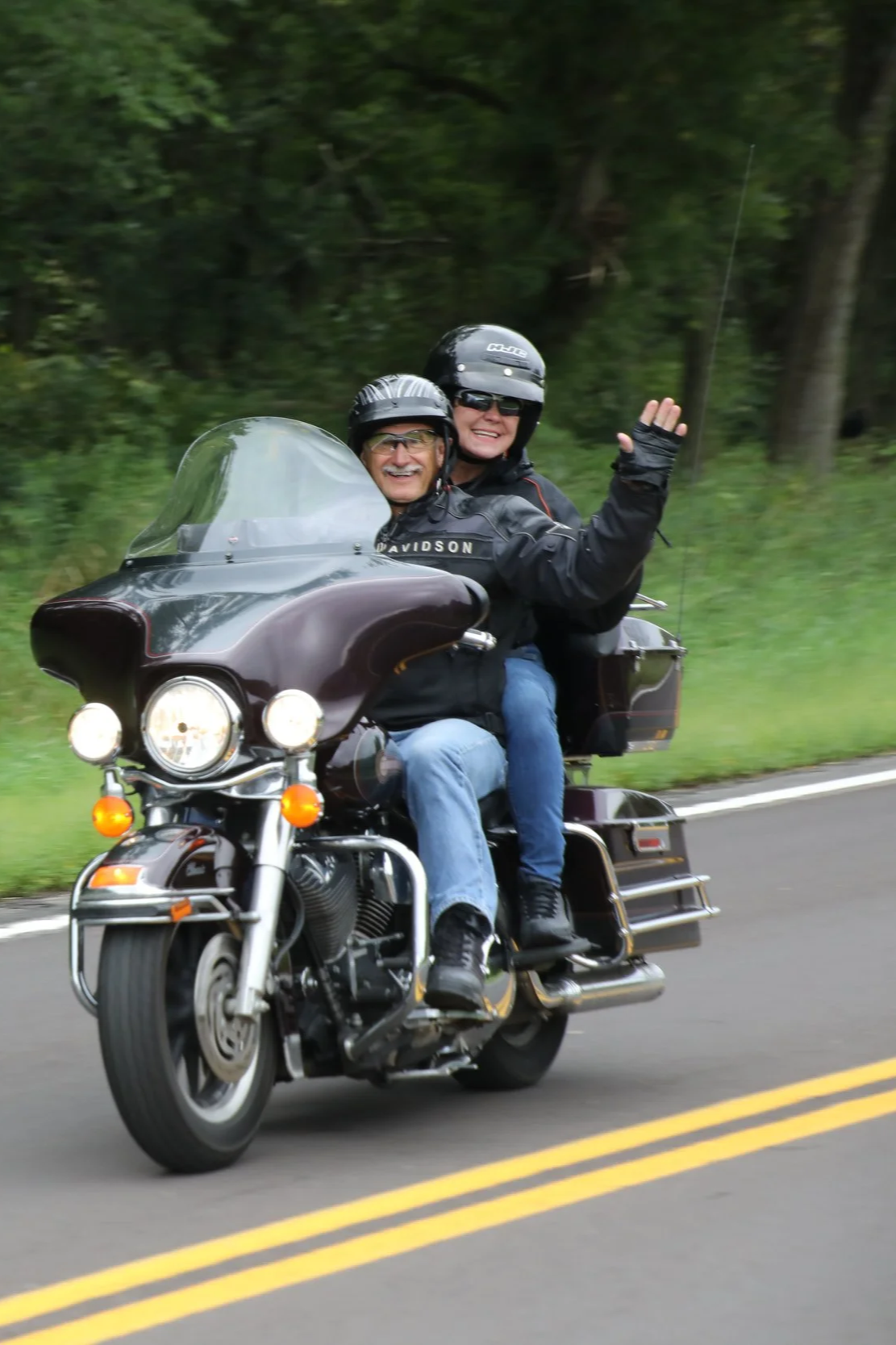 Two participants riding and waving